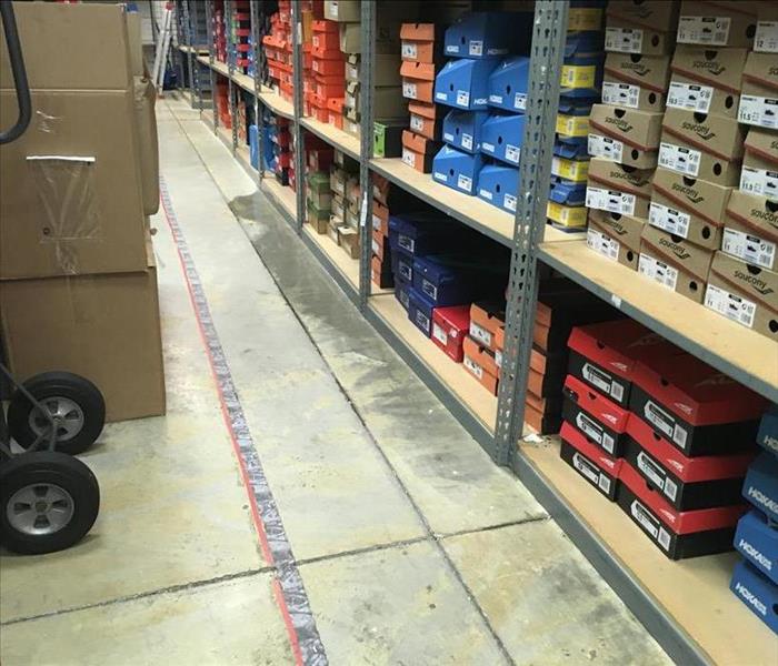 stockroom with boxes of shoes, water on the floor