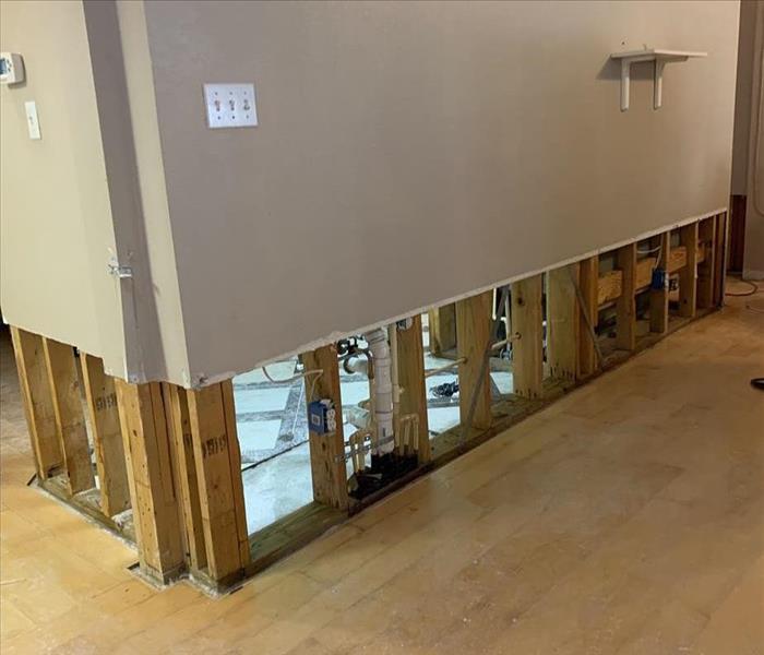 flood cut on wall, showing plumbing, hardwood flooring